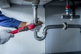 Plumber hands holding wrench doing repairing work at the sink and clogged pipe